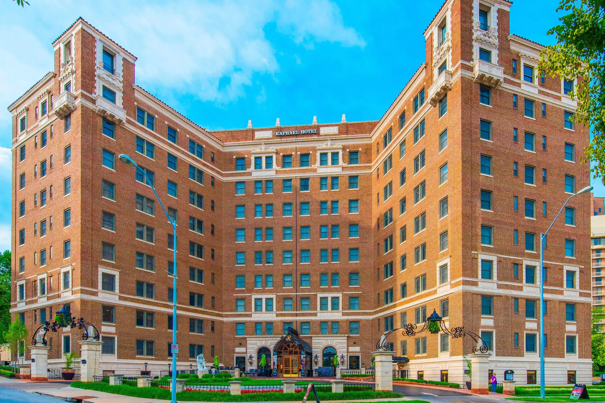 A grand, historic, seven-story brick hotel featuring a U-shaped facade and classic architecture near the Country Club Pl