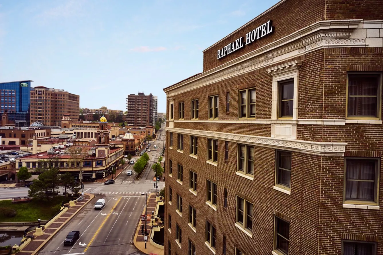 The brick facade of The Raphael Hotel, a historic boutique hotel in Kansas City overlooking the Country Club Plaza under a clear sky.